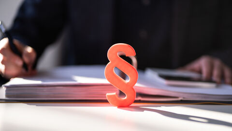 Red paragraph and calculator at judicial attorney desk