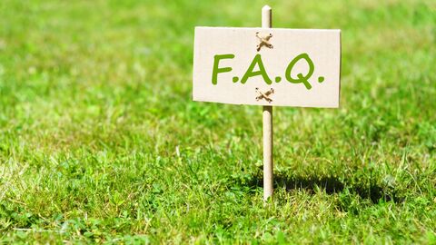 Sign with the title FAQ on a green lawn